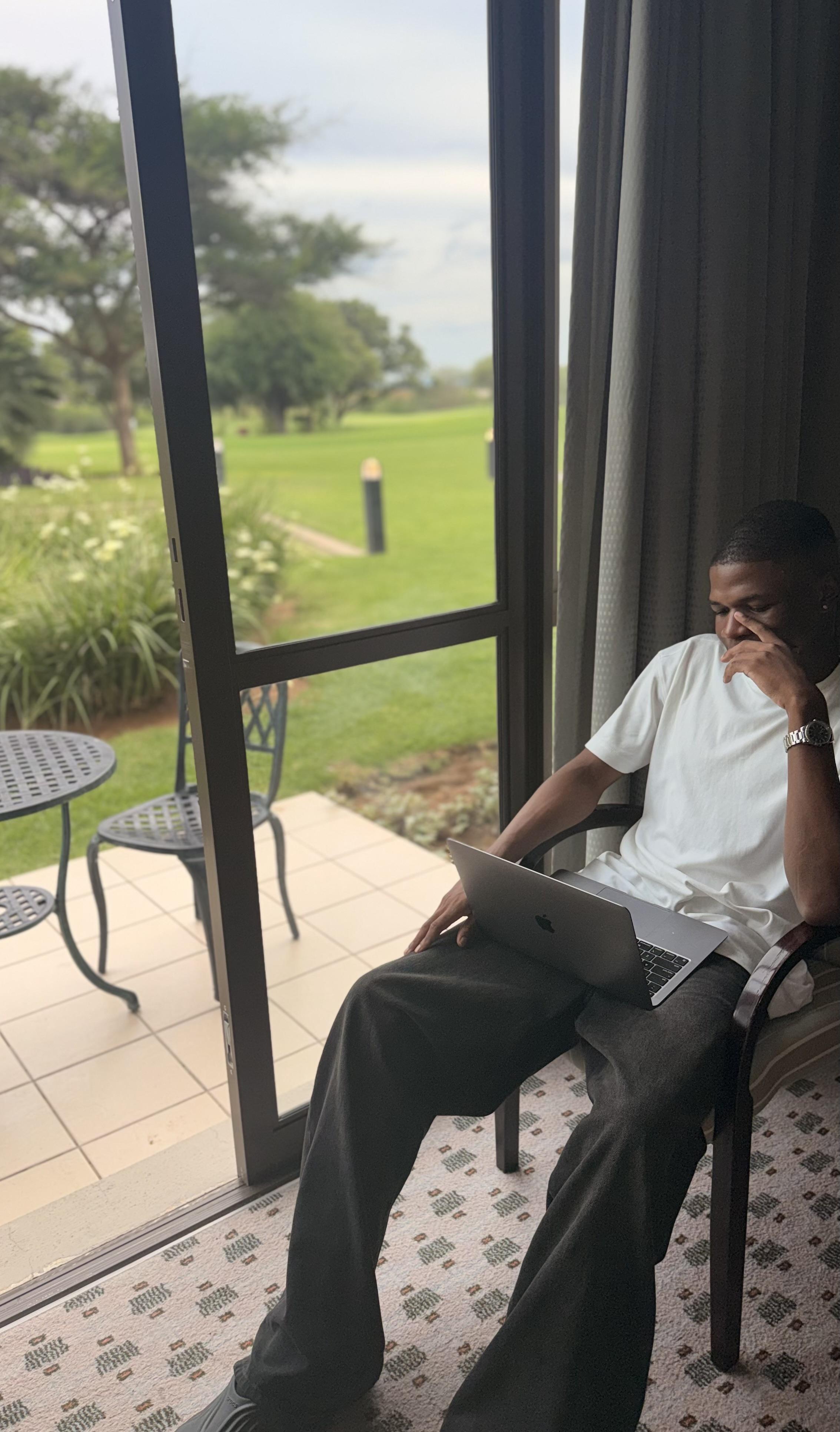 KD working from a hotel patio overlooking the lawn